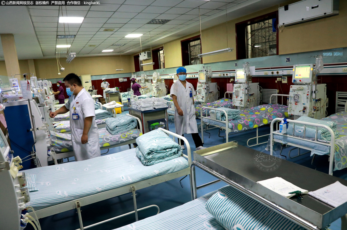      透析基本要求每周达到12小时以上，才能相对清除毒物、水分达标，也就是一周需透析3次，每次4小时。图为李立忠医生巡视患者上机透析前的准备工作。