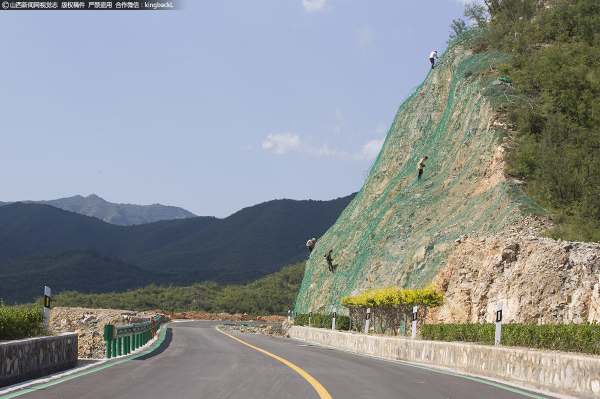      8月30日，在阳泉太行一号旅游公路娘子关至红岩岭景区段，山顶绝壁上护坡工人们头顶烈日，有的在往山上背绿网，有的悬在山崖铺网固定作业，有的正在打边墙落石，一派火热景象。（■山西新闻网特约摄影师：杜爱清）