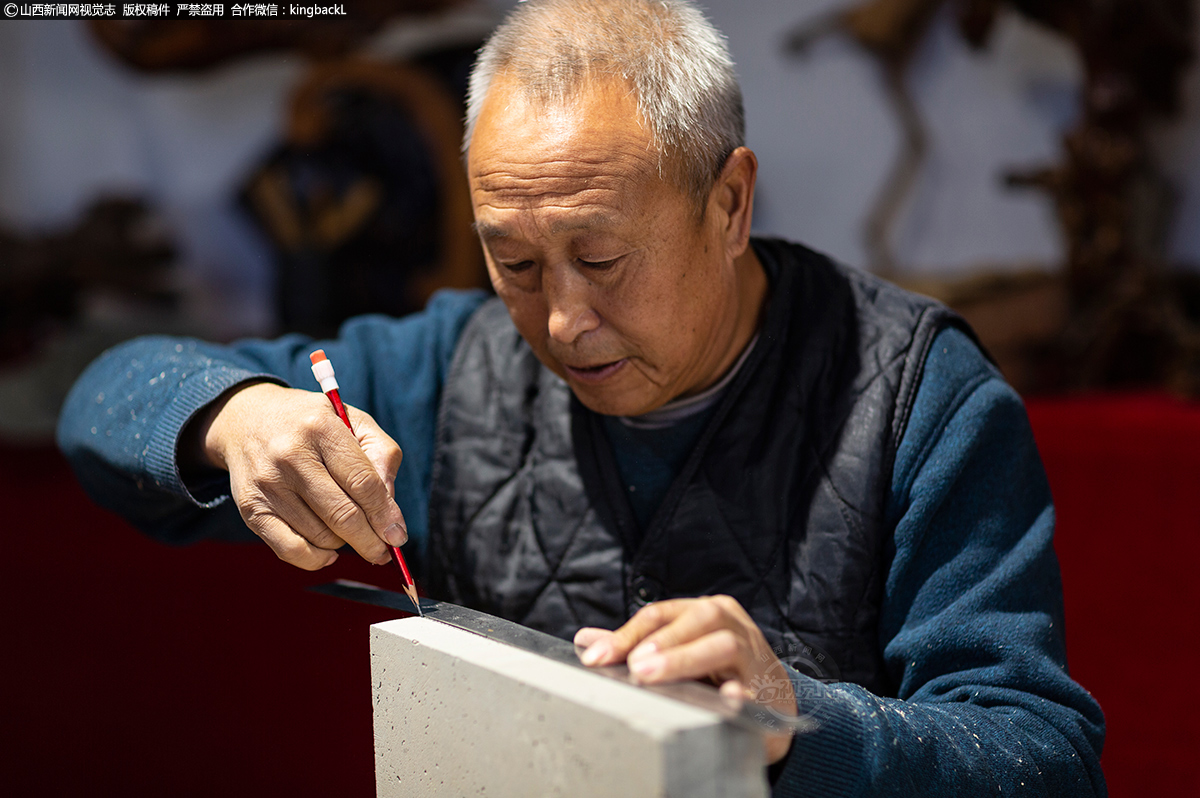      设计稿画好后，王玉亮老师把之前选取好的青砖置于工作台上，开始着手《金蟾献瑞》的创作。在青砖上的创作过程，大致与画稿过程基本相同。但不同的是要考虑从平面向立体的过度。画出中缝，也就决定了这件砖雕作品的雕刻深度。在只有数厘米的空间内要镌刻出各种层次、各种纹饰，其中的难度可想而知。