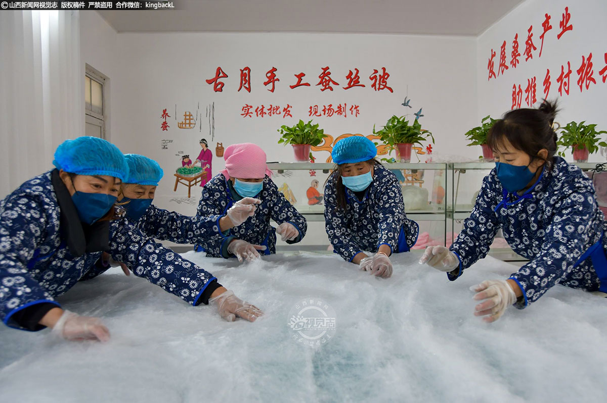      寒冬虽冷，生产火热，近日，走进芮城县古月蚕丝被生产车间，几名工人正在手工制作蚕丝被，呈现出一幅忙碌的景象。（■本期摄影：徐应杰）