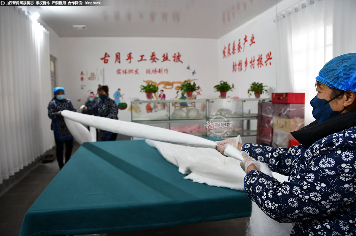      拉伸，首先将一只只晒干的半圆形的绵兜，扯开一个缺口，拉成绵片，然后由四人面对面，拉住绵片四端，控制拉拽力度，它要依照密度需求，不强不弱、不急不慢地绷扯。