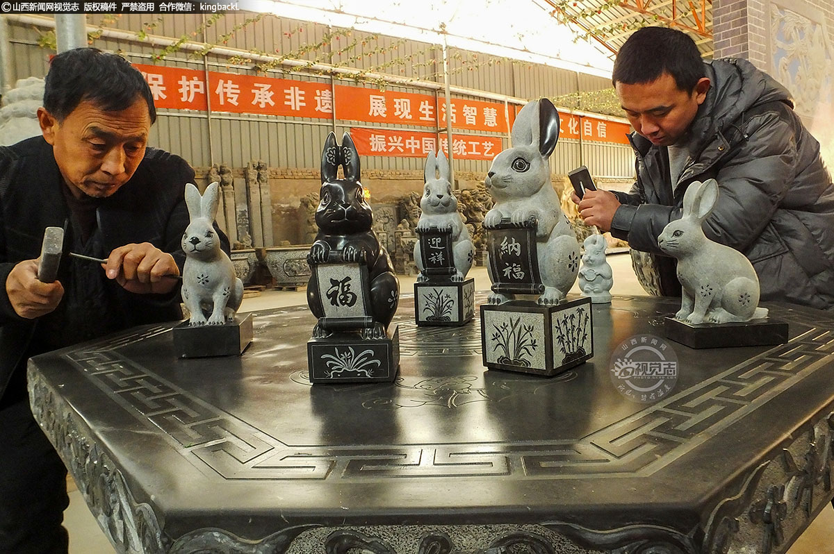      图中，父子二人正在抓紧最后的修饰，以便呈现更好的作品。这些石雕生肖兔活灵活现，憨态可掬，不管从纹理、造型还是动态感都非常耐看、有形。