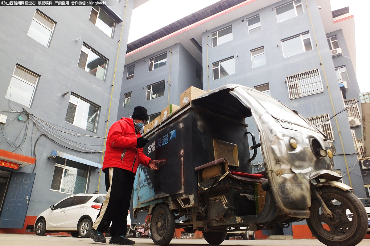      在运城市新绛县四府街社区一居民小区，一名快递小哥冒着严寒为居民送快递。为了保证居民在网上置办的各类物品能够顺利抵达，快递小哥们默默坚守岗位，他们穿梭在城市的大街小巷中，不畏严寒，用最快速度把快递送到每一个客户手中。