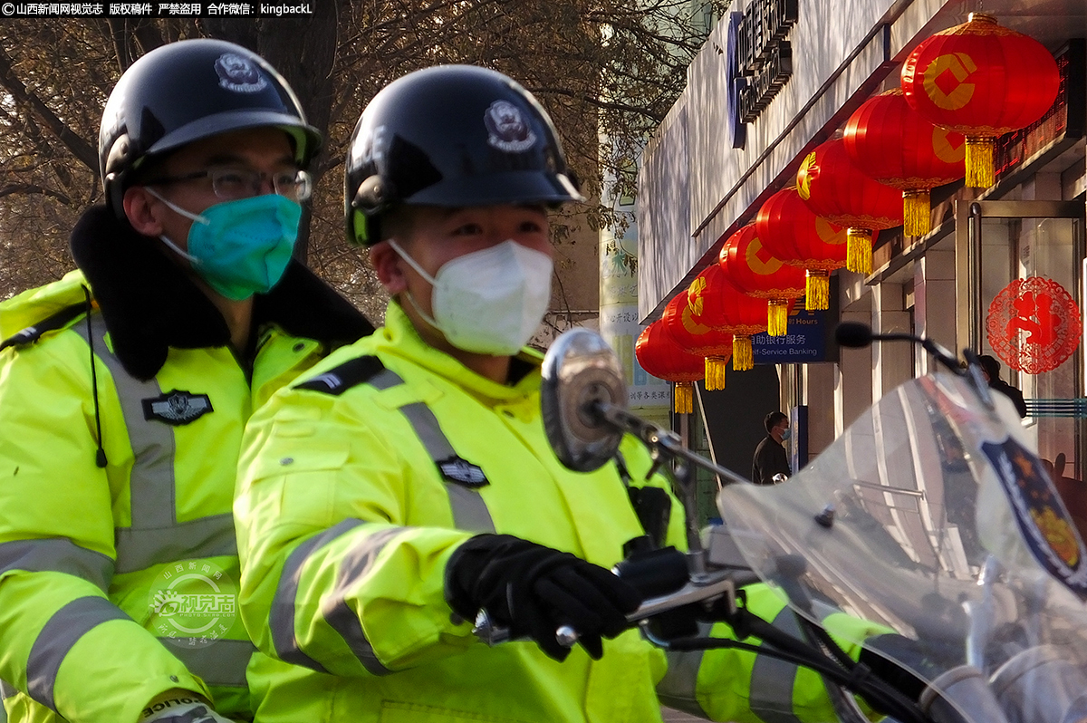      在新绛县正平街，两名交警在挂满红灯笼的街头巡逻。对于交警来说，过节更意味着坚守与使命，守护在各个路口，穿梭在车流人海。