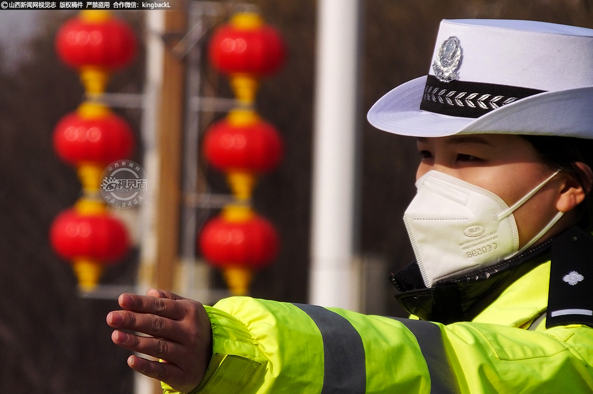      绛州新城，一名交警在挂满红灯笼的街头指挥交通。他们在不同的岗位上坚守，只为换取万家团圆。