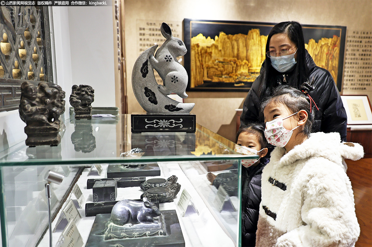      本次展演旨在丰富群众新春文化，感悟中华五千年传统文化精粹，让传统非物质文化遗产“活”起来。图为两名小朋友在家长的带领下驻足观赏绛州石雕兔。