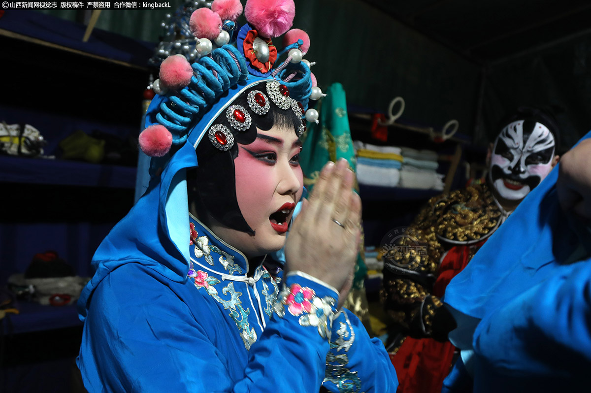      女兵已经穿戴好，马上就要出场，因为需拿刀出场，她们先用嘴把手哈热。