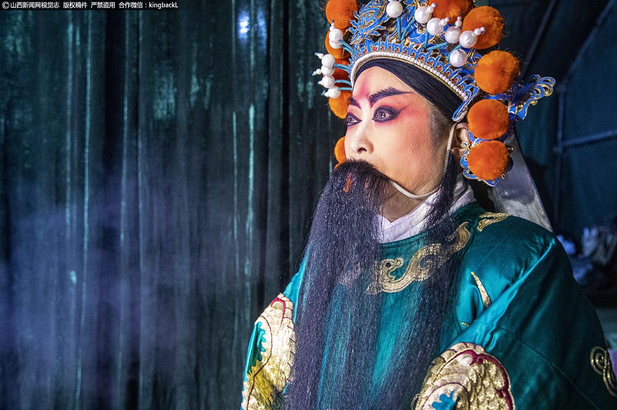      这位须生“杨六郎”的扮演者站在幕布前口中吐着白气，胡子上已经结了冰疙疤，但只要一上台，她们就会把寒冷全都忘掉，专注于自己的表演。
