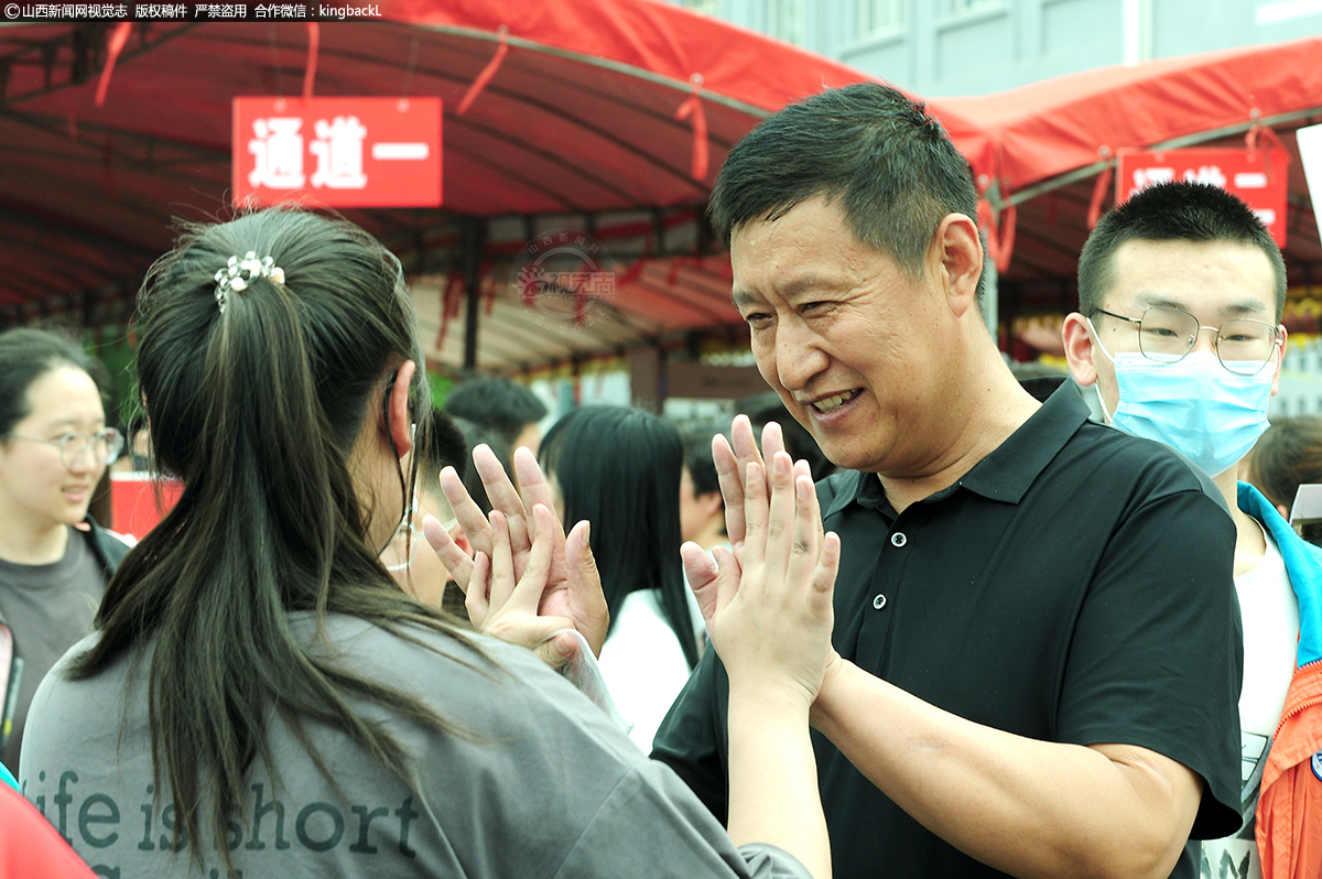      6月7日，在万荣中学考场外，考试结束考生与家长击掌相拥。（■摄影师：张怀心）