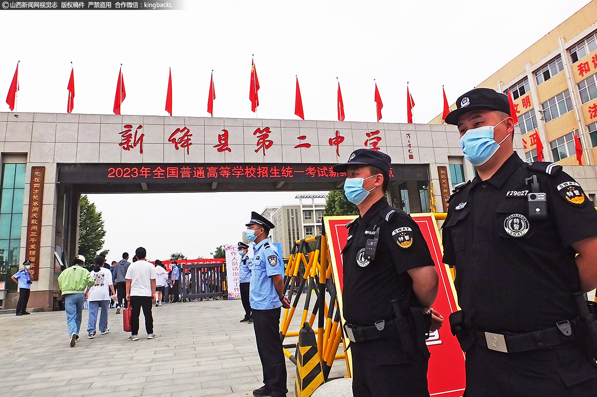      6月7日，在运城市新绛县第二中学考点，民警和特警护送考生进入考场。（■摄影师：高新生）