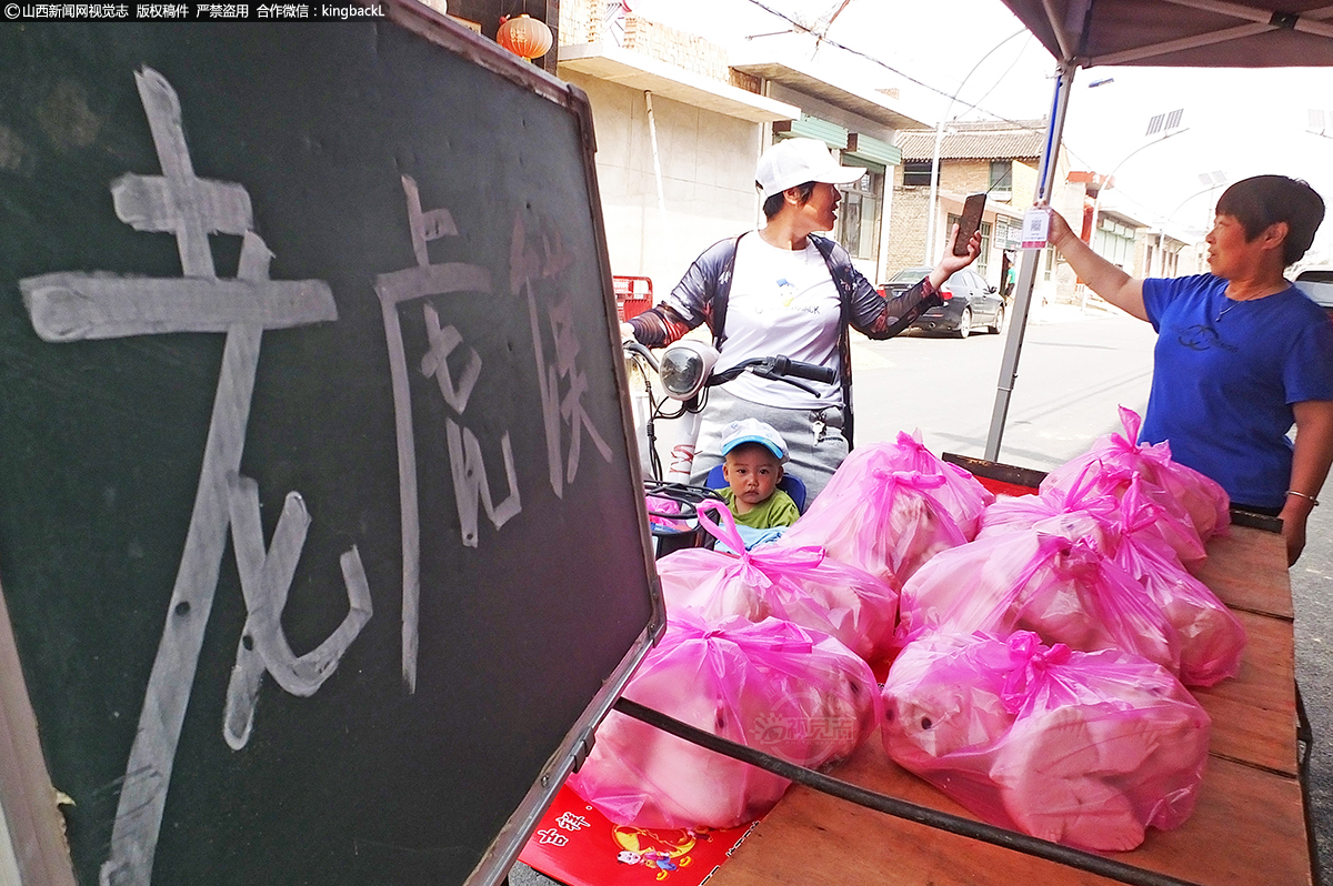      一名村民在选购花馍。作为中华文化的发源地之一，黄河流域各种民间艺术异常发达，蒸花馍则是具有代表的优秀文化之一，一直传承至今。