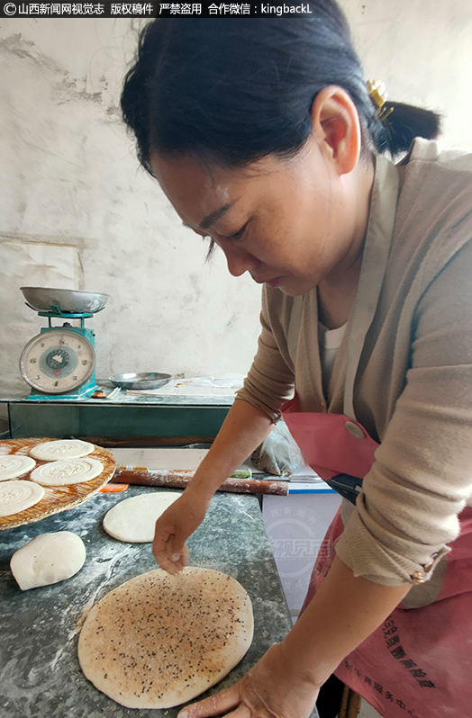      手工月饼的制作有10多道工序，首先揪下适量的面团在案板上揉圆压扁，把芝麻、花生、瓜子仁等搅拌成的馅料包入面饼里。