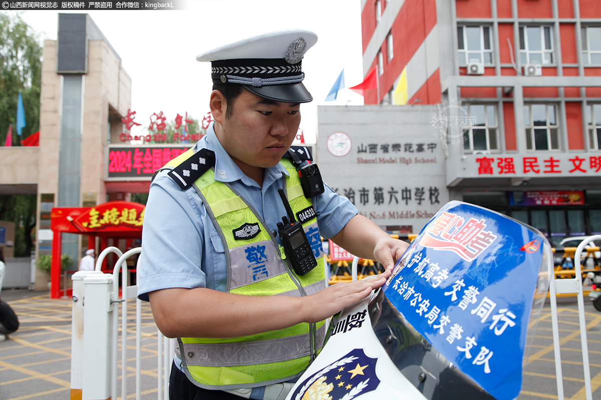      6月7日，山西长治市第六中学考点，交警粘贴爱心助考标识。（山西新闻网特约摄影师：张向军）