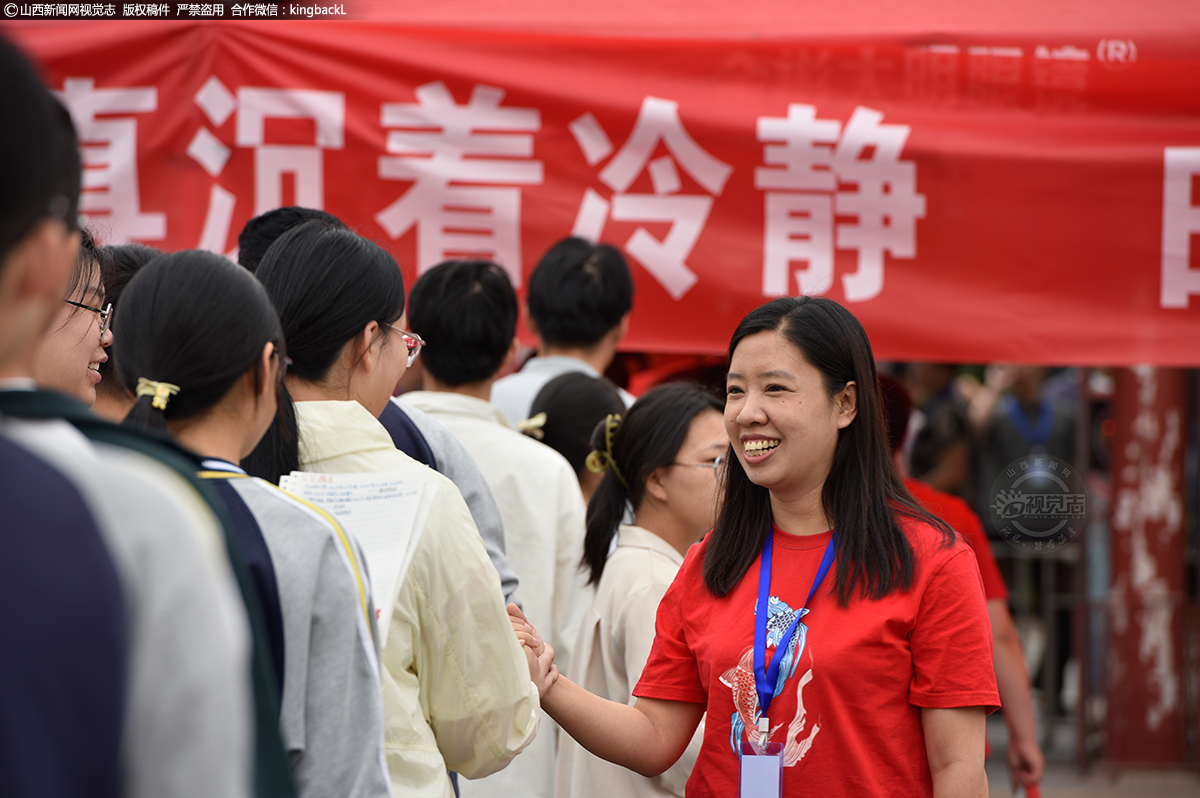      6月7日，在山西省曲沃县曲沃中学考点，送考老师与考生击掌鼓励。（山西新闻网特约摄影师：杨立国）