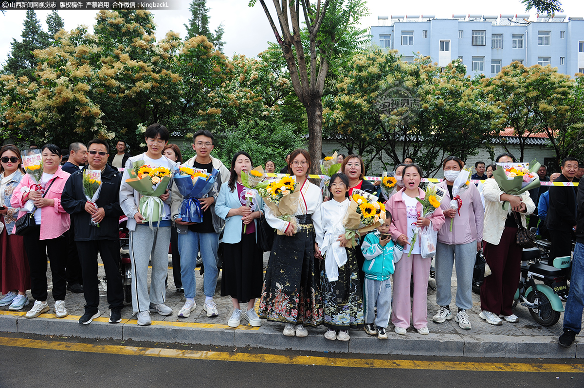      6月7日，山西浑源中学考点外，考生家人在马路对面手捧鲜花等待考生。（山西新闻网特约摄影师：杨钦）