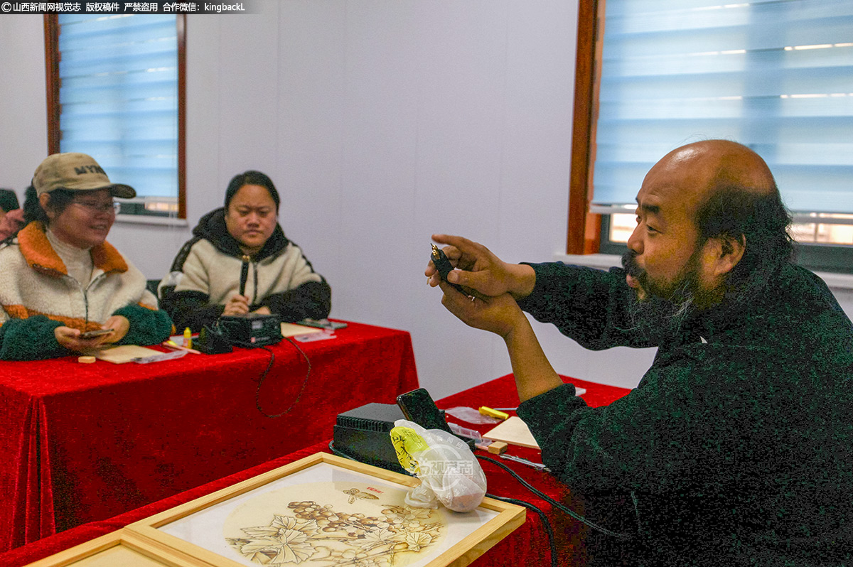      活动现场，李保华向居民们详细介绍了烙画的历史渊源、艺术特色及制作工艺。
