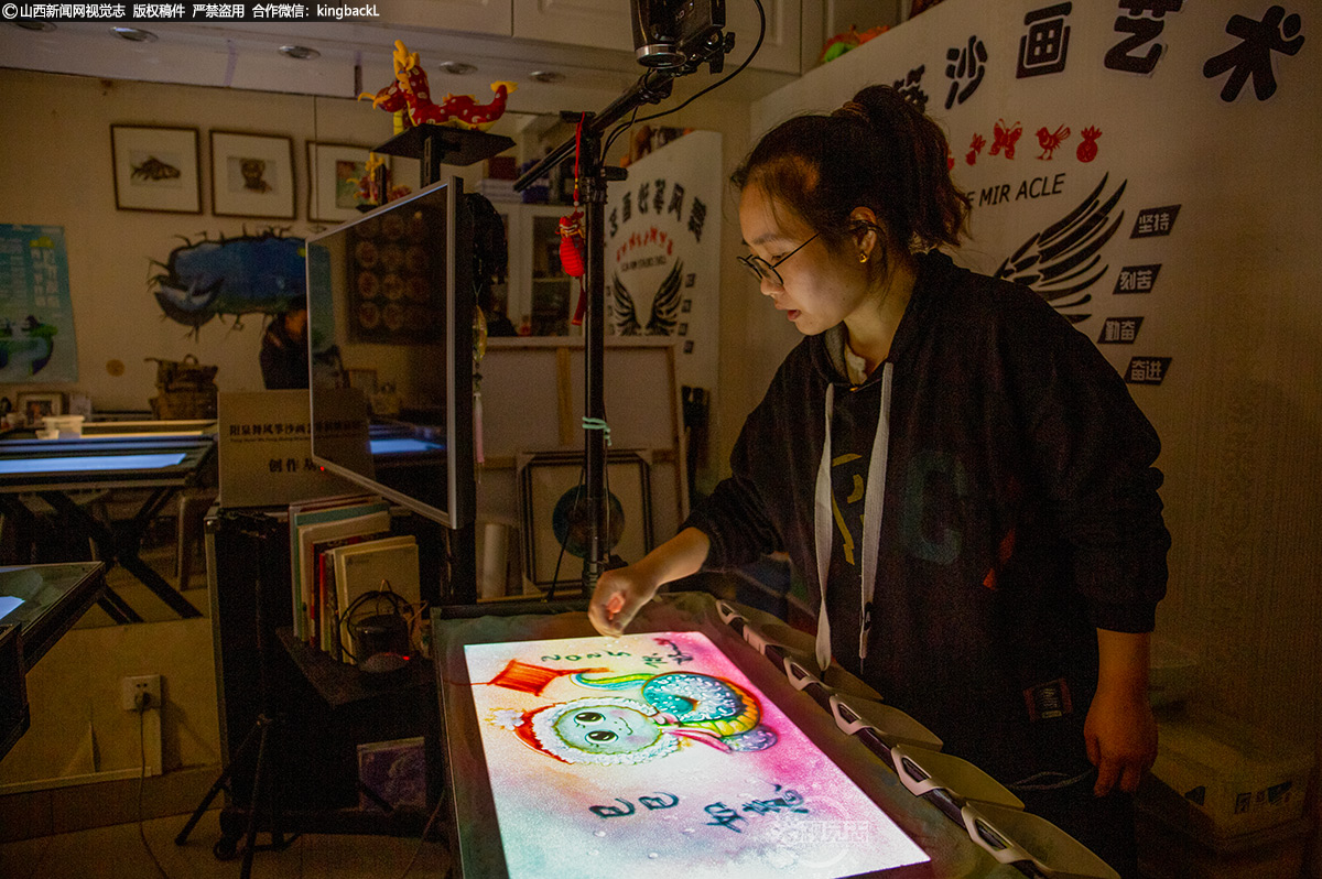      12月29日，阳泉矿区的“80后”女沙画师武丰珍，在她的个人工作室里，正专心致志地创作着寓意吉祥的“已已如意”蛇与“大橘大利”龙沙画，以流沙寄托对新年的美好祝福。一把流沙，仿佛蕴含着整个世界；在她的手掌间，流淌出无限的美好与创意。（■山西新闻网特约摄影师：杜爱清）