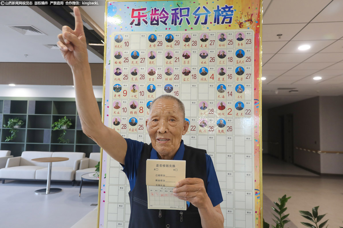      积分榜前傲，荣誉心中耀。88岁的谭胜德老人站在乐龄积分榜前自豪地伸出了手指。在康养中心，所有老人根据参加日常活动多少进行积分考核，凭积分年底可兑换礼品。这一举措激发了老人们参与活动的积极性，让他们在享受乐趣的同时，还能收获一份荣誉和奖励。