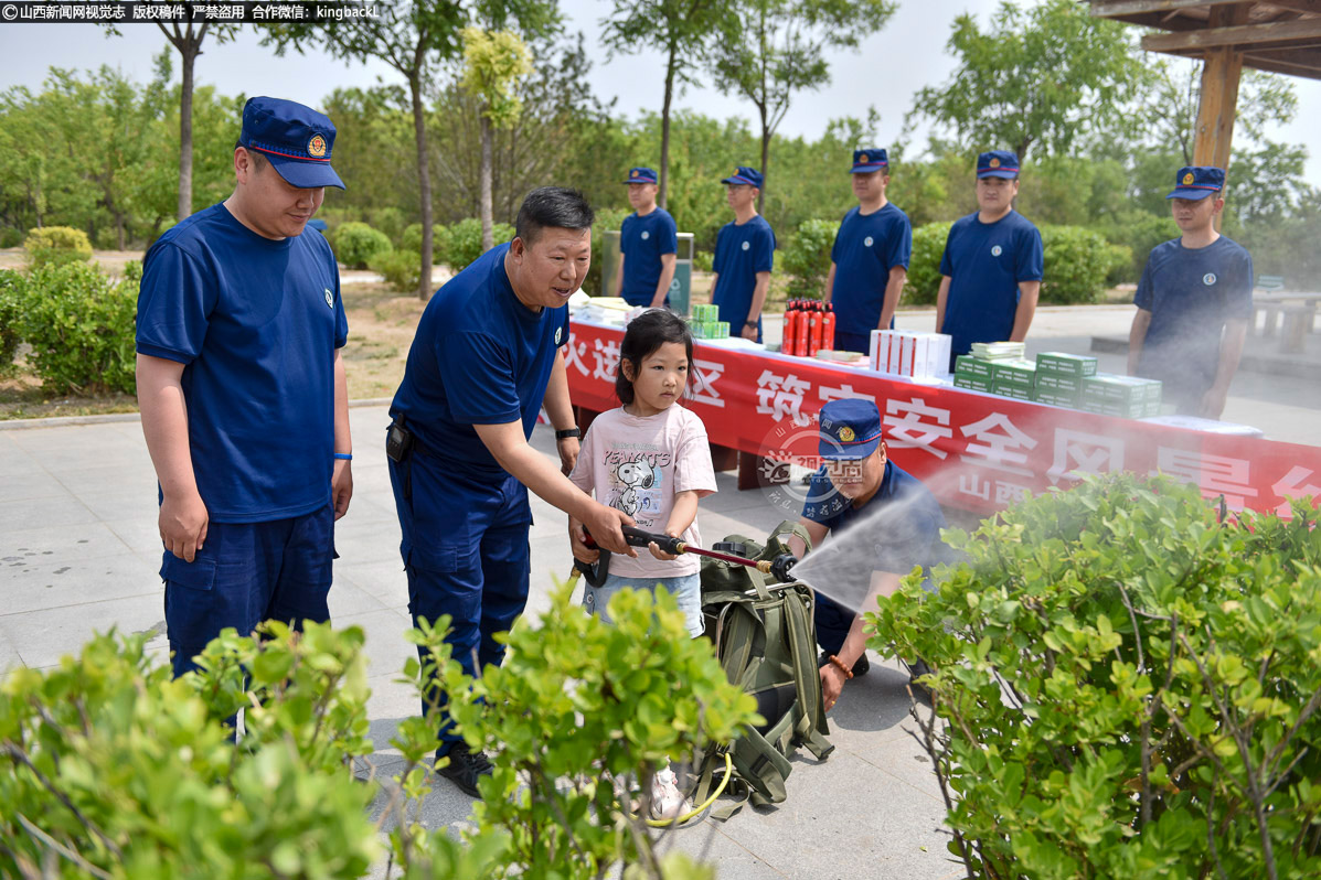      一名小朋友在消防员指导下体验高压细水雾灭火机。这种沉浸式体验最受欢迎，通过实际操作让防火知识入脑入心。