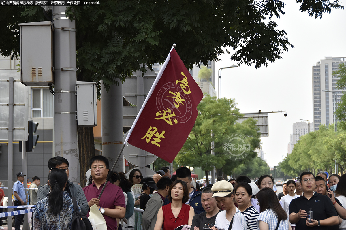      6月7日，山西太原三十八中考点，家长举“高考必胜”旗子为考生助力。山西新闻网特约摄影师：付宇林