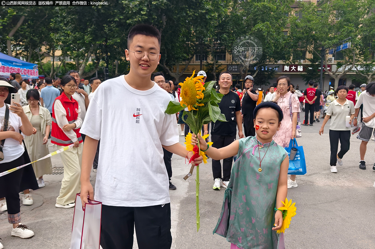      6月7日，在临汾市第三中学考点，妹妹给哥哥送上盛开的葵花，祝他一举夺魁。山西新闻网特约摄影师：张向东