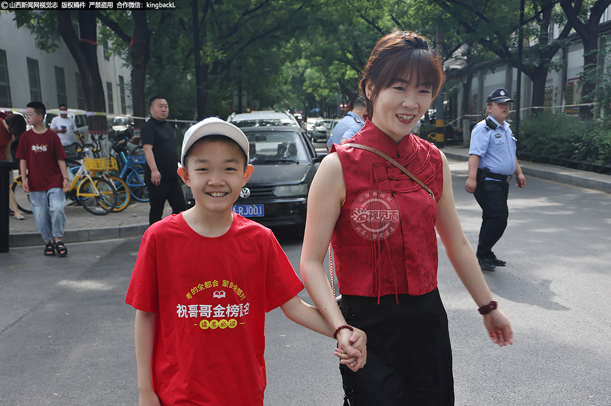      6月7日，太原市平民中学考点，弟弟身着“祝哥哥金榜题名”的文化衫为参加高考的哥哥加油鼓劲。山西新闻网特约摄影师：杨利