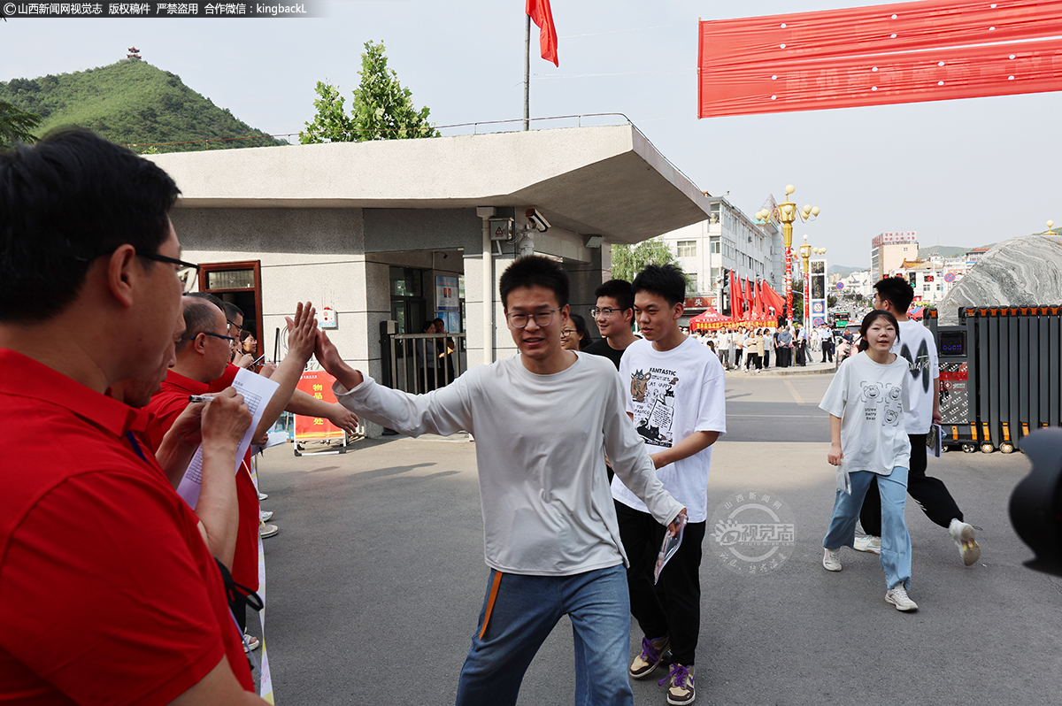      6月7日，在山西平顺中学考点，考生走进考场时，老师与考生击掌为其加油。摄影师：王超