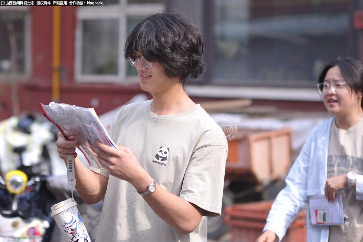      6月7日，山西太原，一位考生在排队入场的间隙复习，临阵磨枪，不快也亮。
