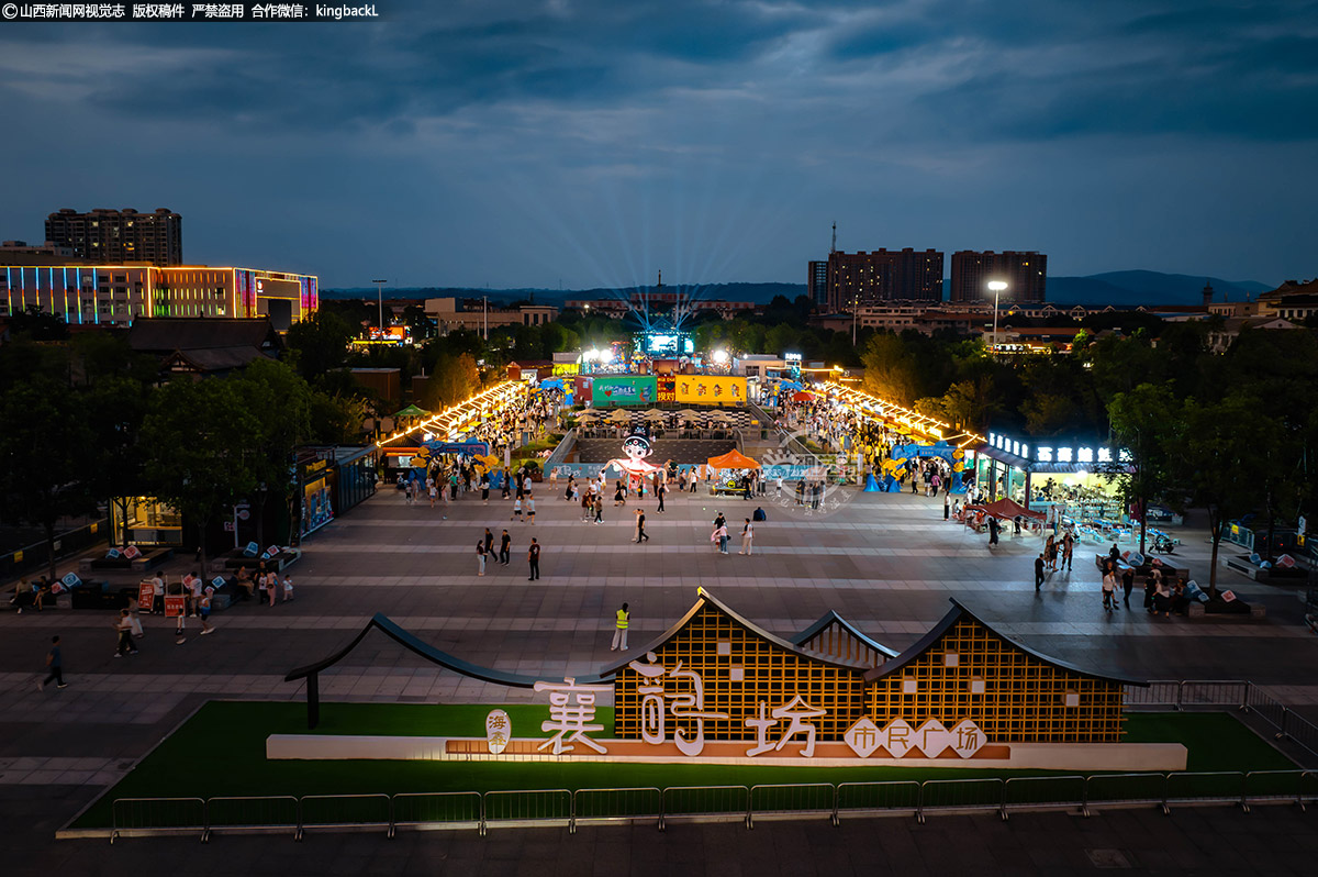      7月4日，暮色四合，霓虹灯逐渐点亮夜空，山西省襄垣县襄韵坊市民广场又开始热闹起来。（■本期摄影：付宇洲 连彦玲）