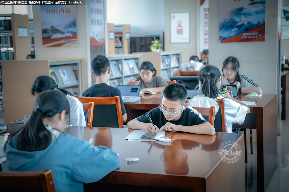      大家在阅览室内或凝神翻书，或伏案自学，在空调带来的清爽中享受静谧阅读时光。