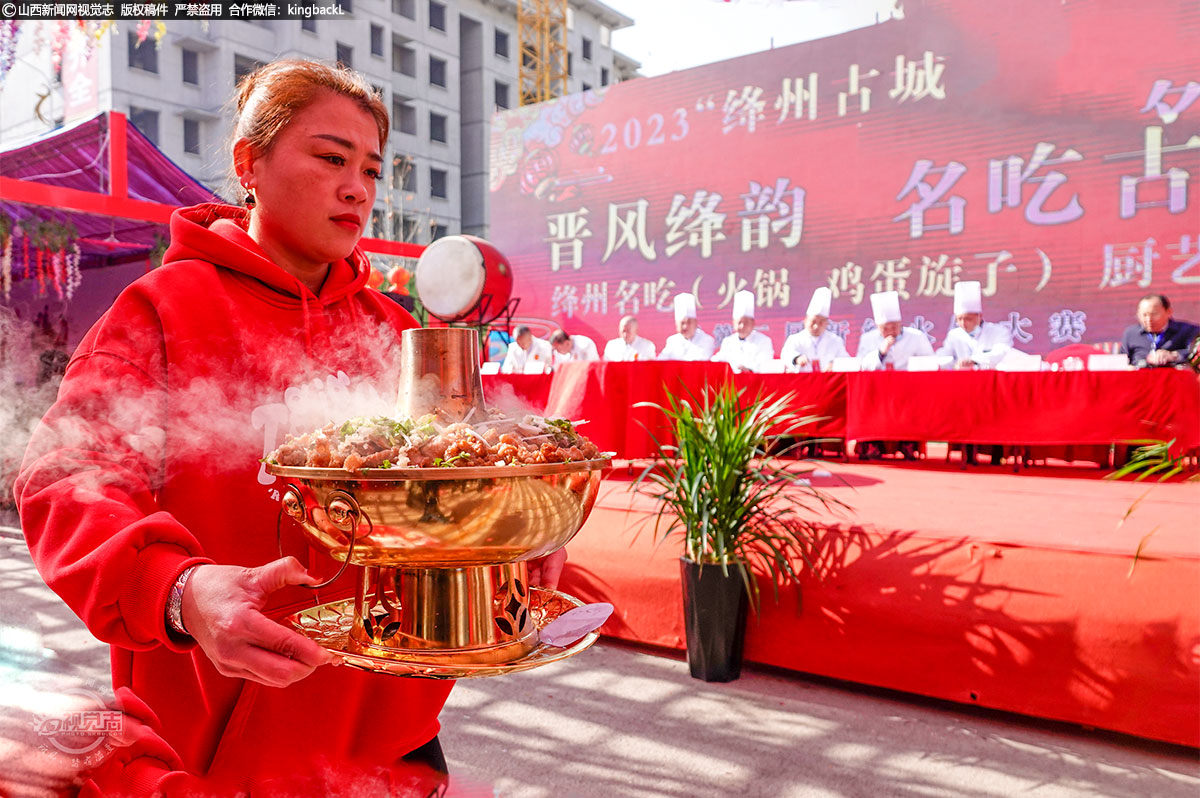      大赛现场面味、菜味、汤味、烟火味扑鼻引人，笼罩赛场。图中，工作人员正将参赛选手做好的火锅端上评审席打分。