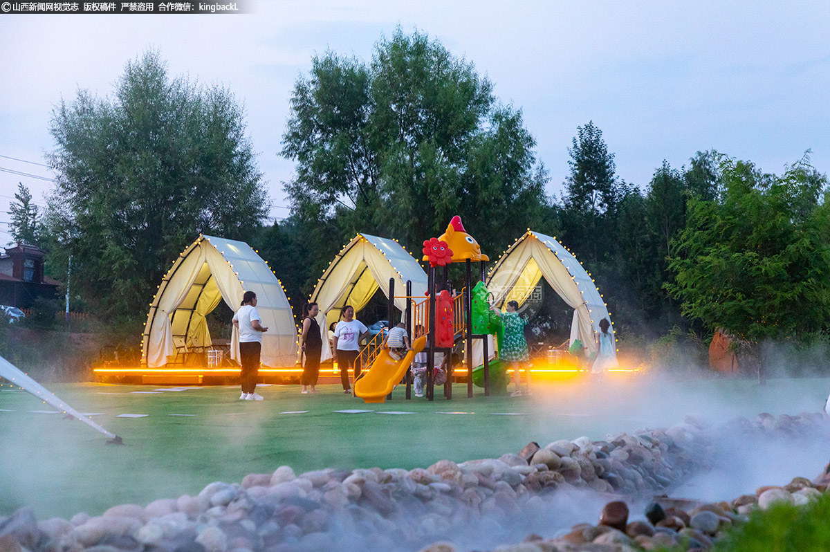      今年夏天，沉浸式露营成为避暑新风尚，“拥抱乡野”备受热捧。在山西省襄垣县虒亭镇宝峰湖畔的建华村露营基地，绿意葱茏、溪水潺潺，游客们野餐畅聊、笑语欢声，尽享乡野之趣。（■本期摄影：韩松涛   王晨   马静）